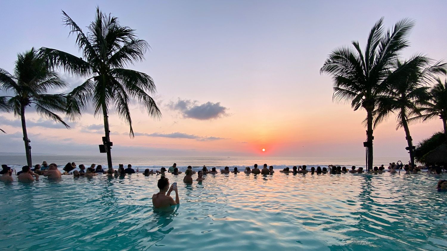 An infinity pool overlooking the sea at sunset in Bali